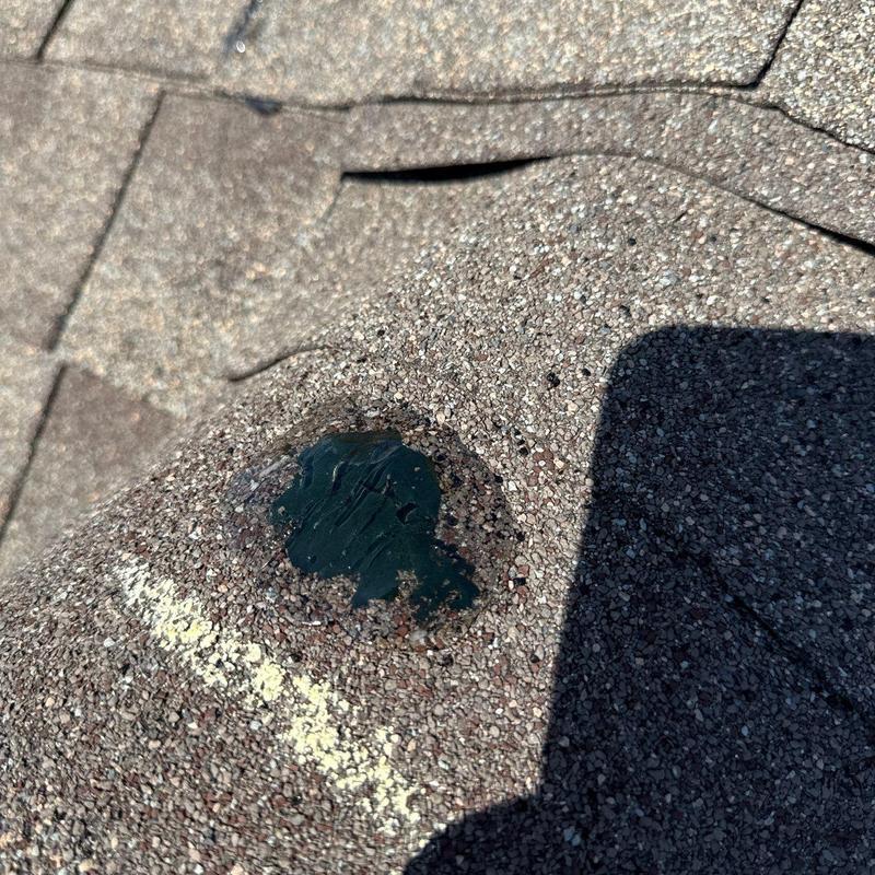 Asphalt shingle with hail impact repair sealant applied