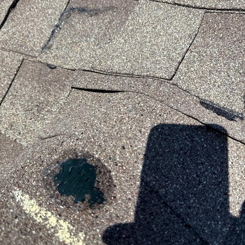 Asphalt shingle roofing with hail damage and cracked tabs