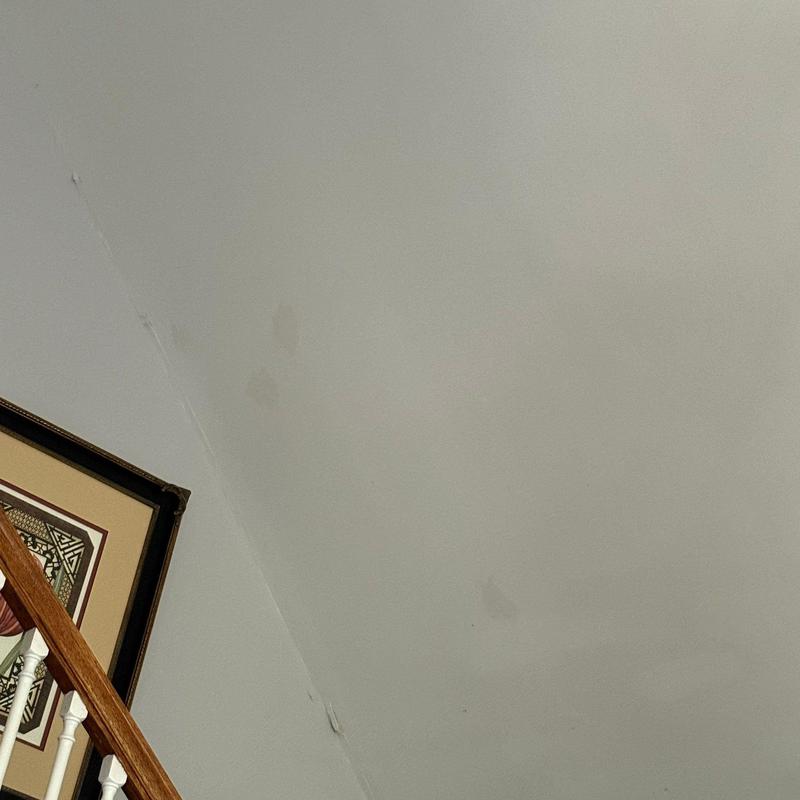 Ceiling water stains near staircase wall