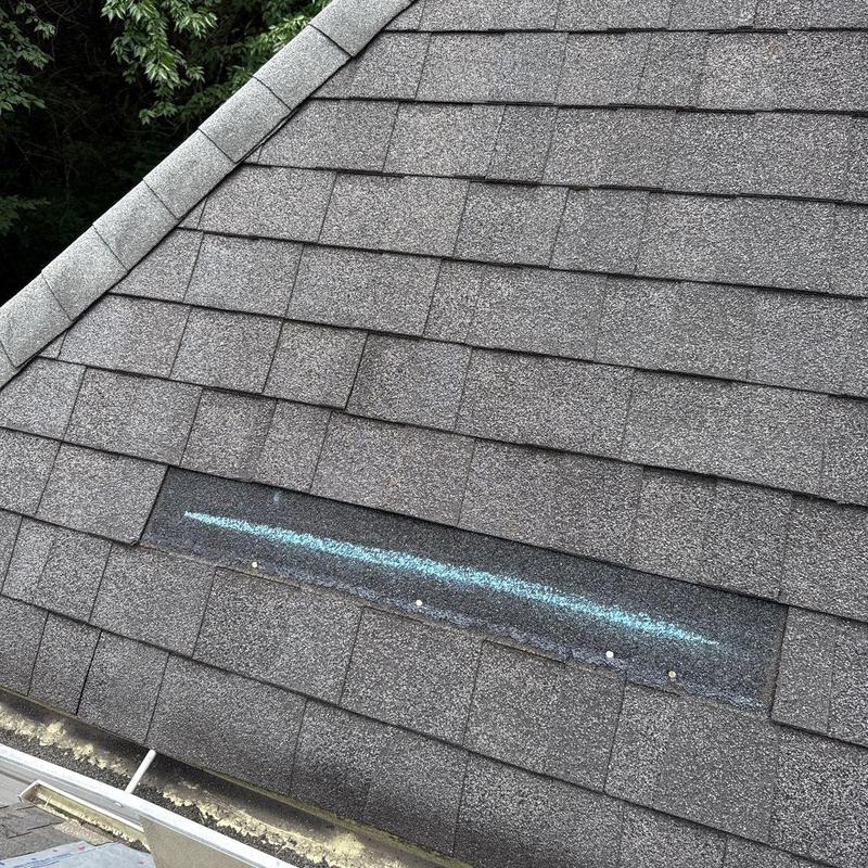 Hail-damaged roof shingles with chalk marking