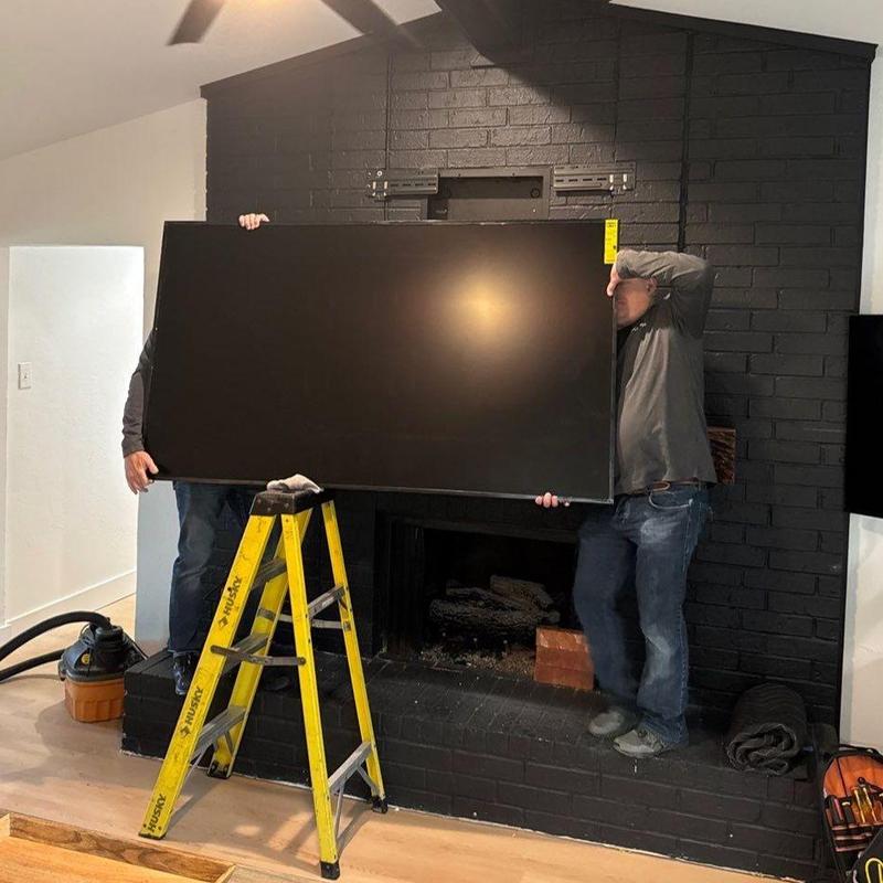 70-inch TV mounting on black brick fireplace wall