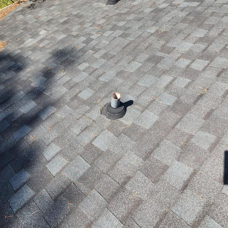 Roof shingles and vent pipe flashing on asphalt roof