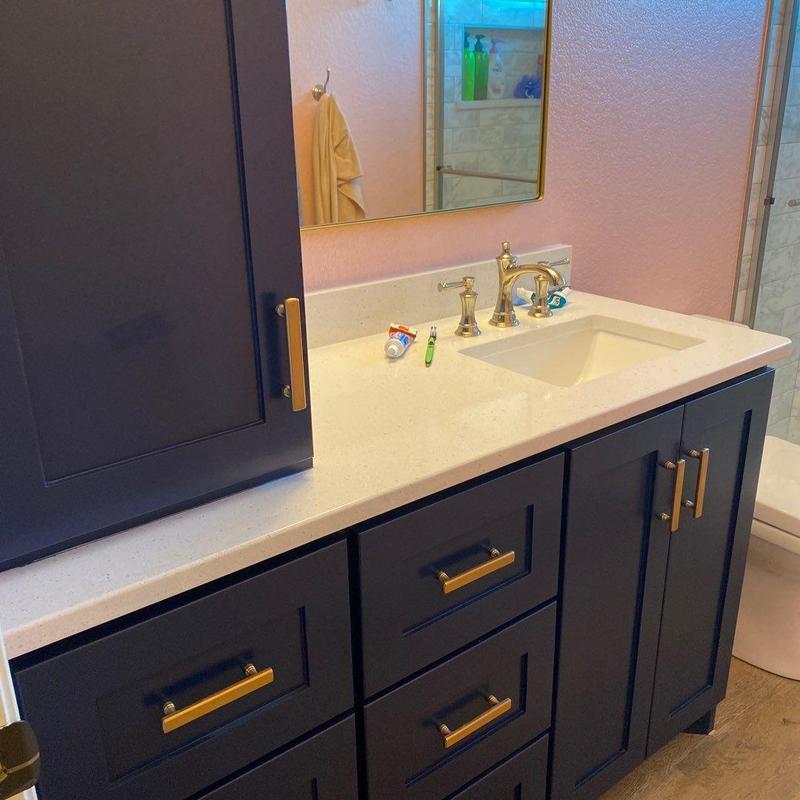 Quartz countertop and navy vanity cabinet in bathroom