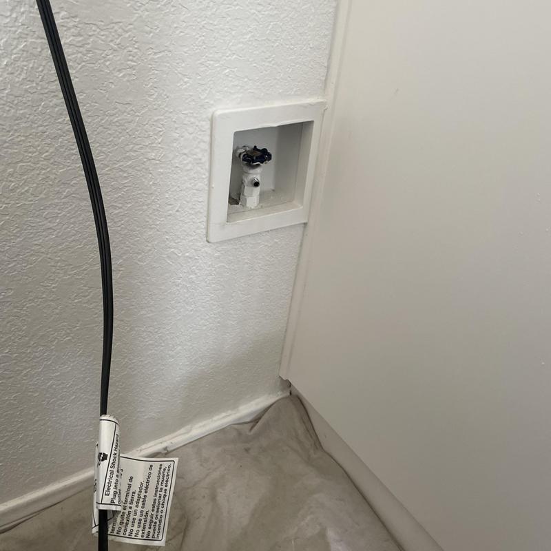Icemaker shut off valve and plumbing box behind refrigerator