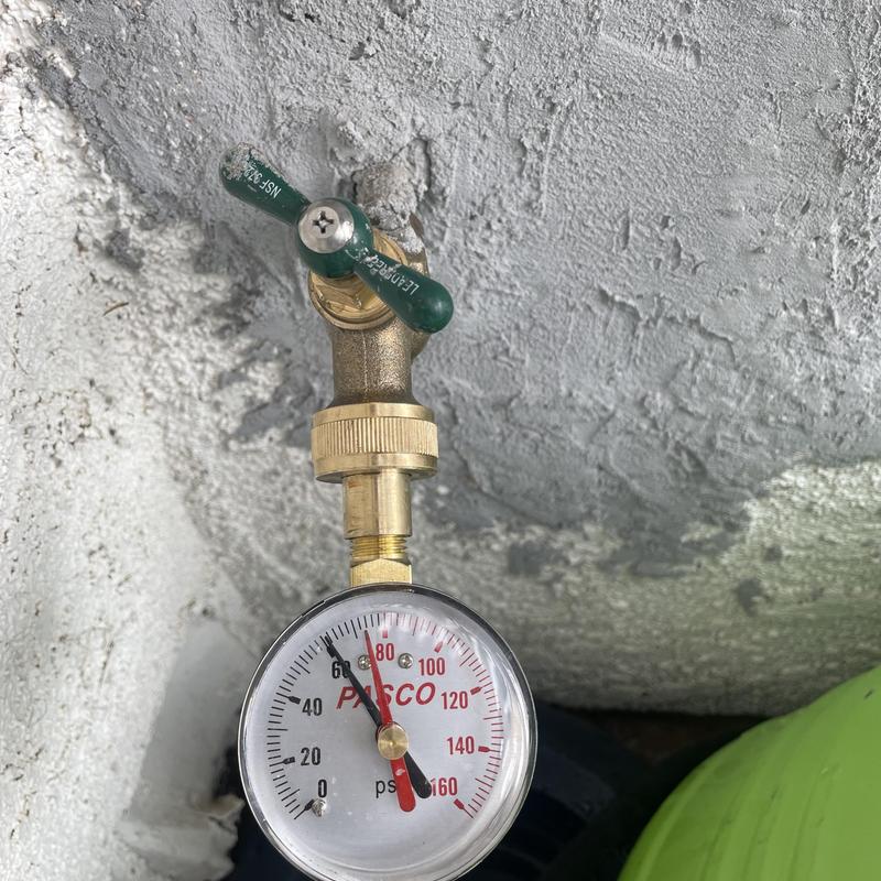 Water pressure gauge with valve on outdoor wall