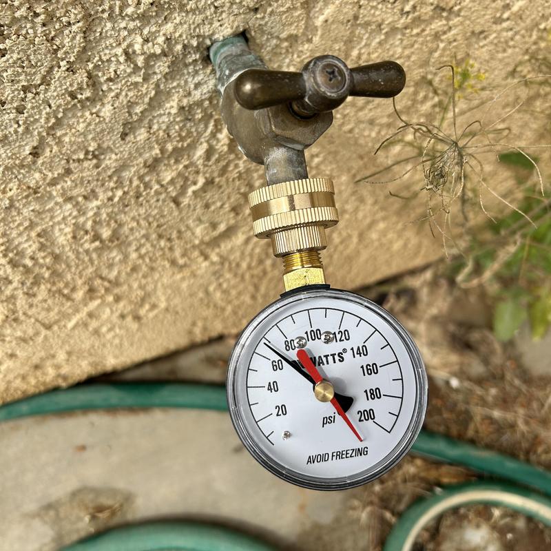 Pressure regulator gauge on outdoor faucet measuring psi