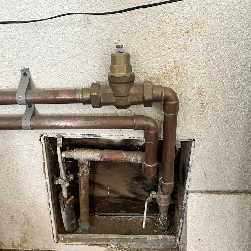 Pressure regulator and copper piping replacement in wall cavity