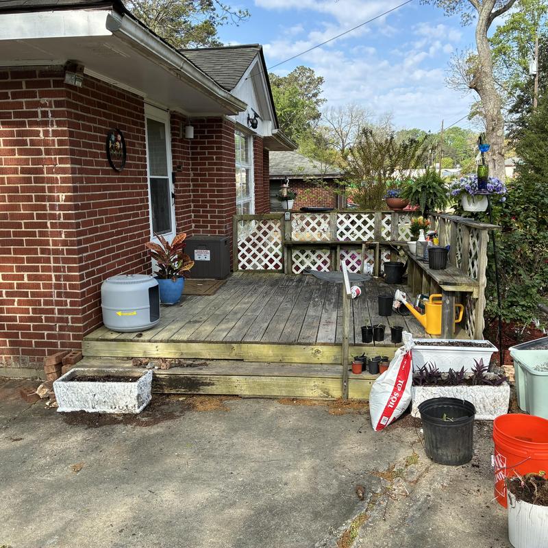 Wooden front porch with railing and steps needing repair