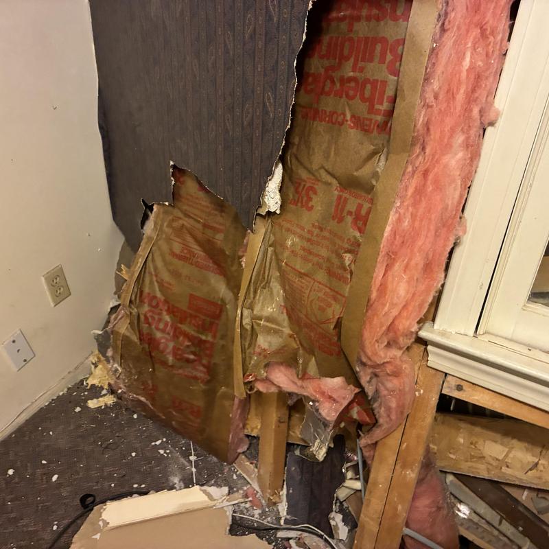 Wall insulation and drywall demolition near window frame