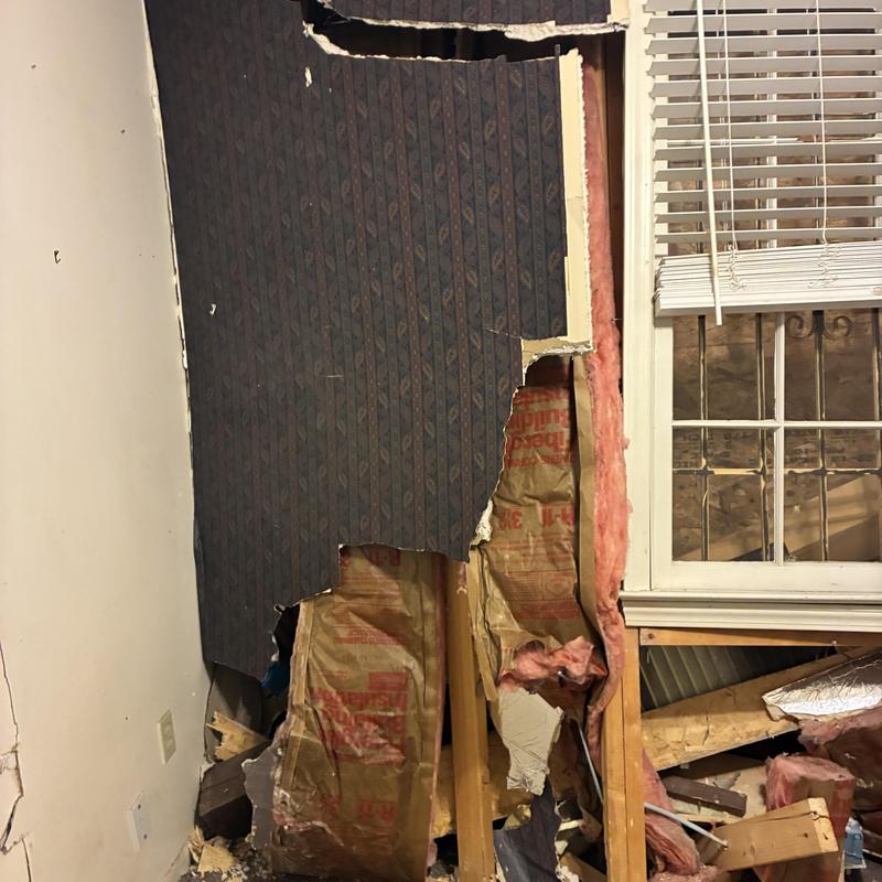 Drywall demolition exposing insulation and wall framing