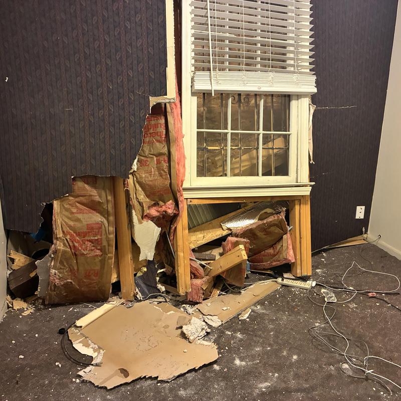 Interior wall drywall demolition with exposed insulation and framing