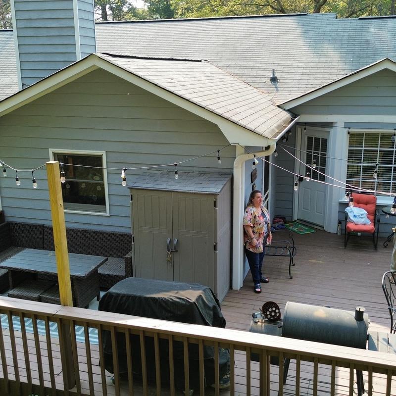 Shingle roof above deck with lighting and outdoor furniture