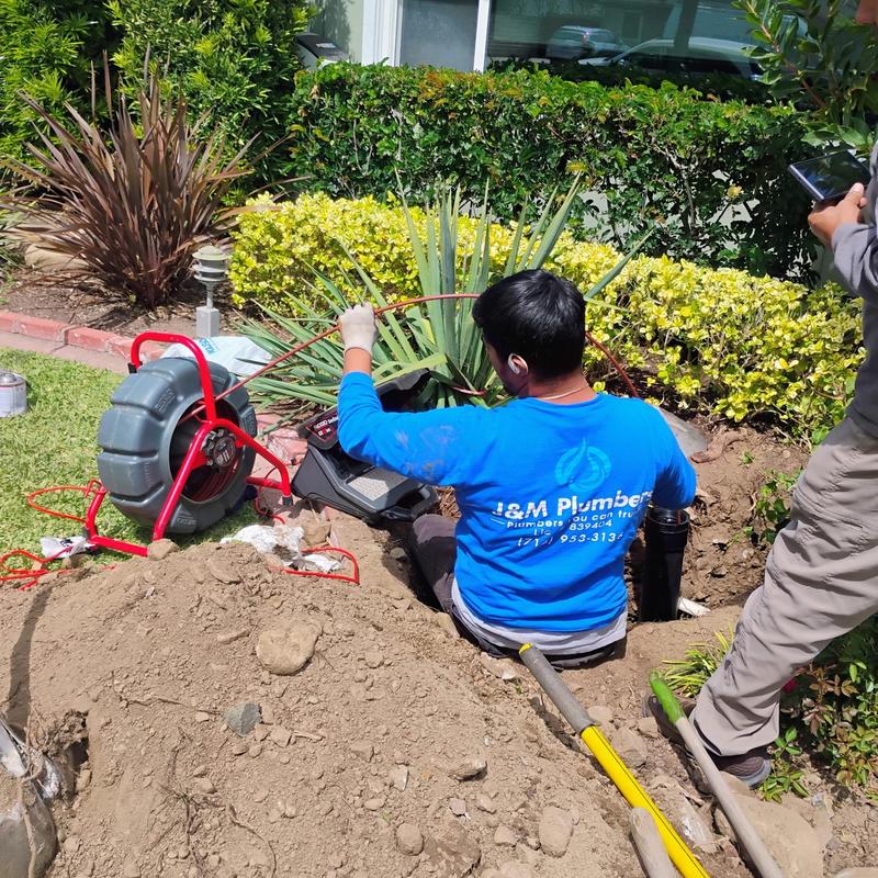 Sewer line cable drain cleaning in residential yard