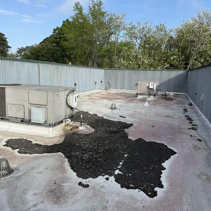 TPO roofing membrane with damaged black patching areas