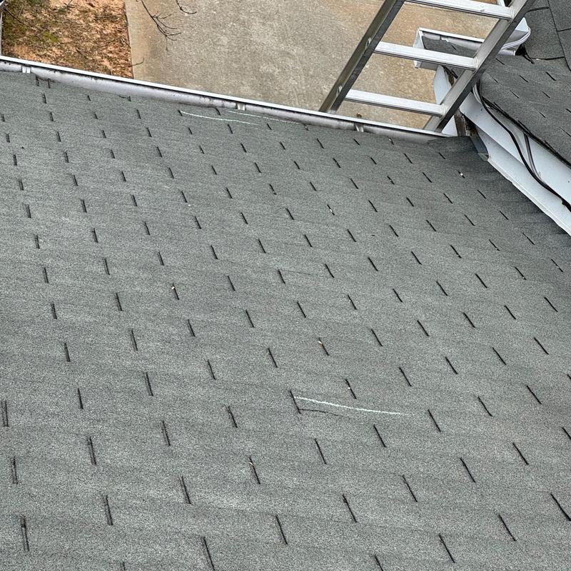 Roof shingles with chalk mark near ladder and pipe boot