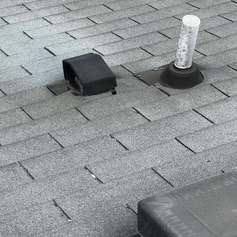 Roof pipe boot and vent on gray shingle roof