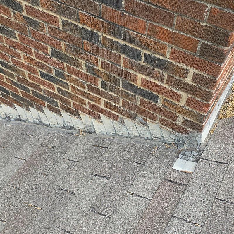 Chimney flashing and shingle roof with hail damage