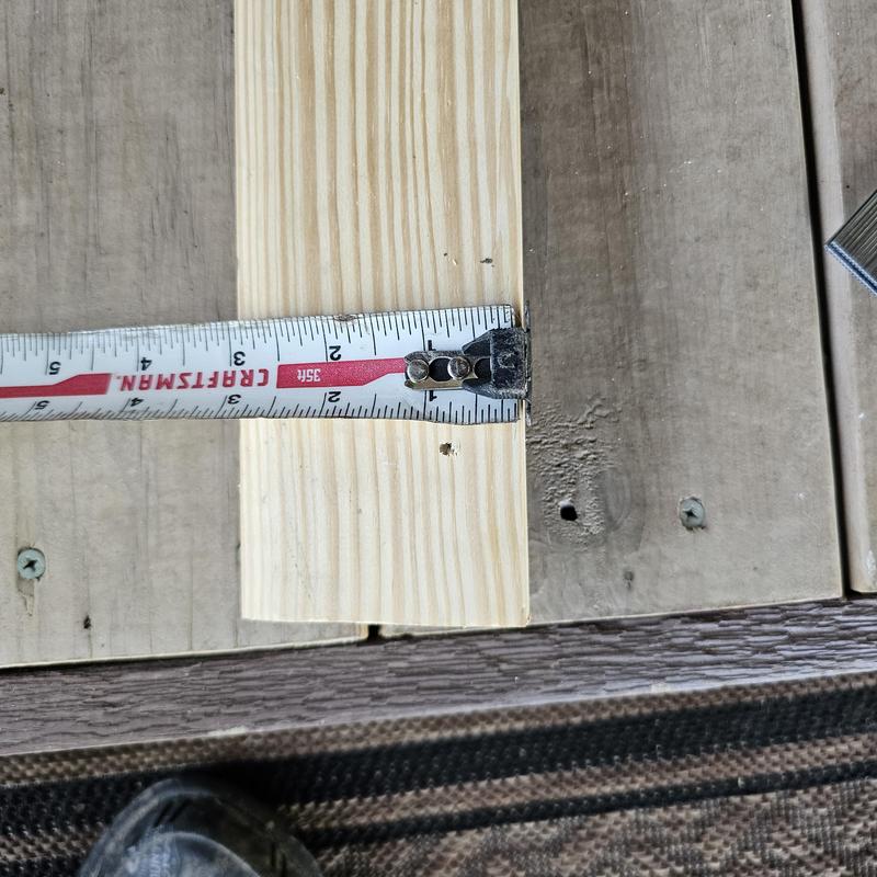Wood deck board with measuring tape and screws