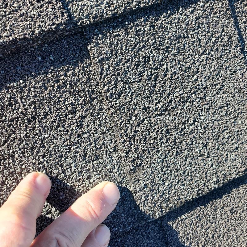 Asphalt roof shingles with hail damage close-up
