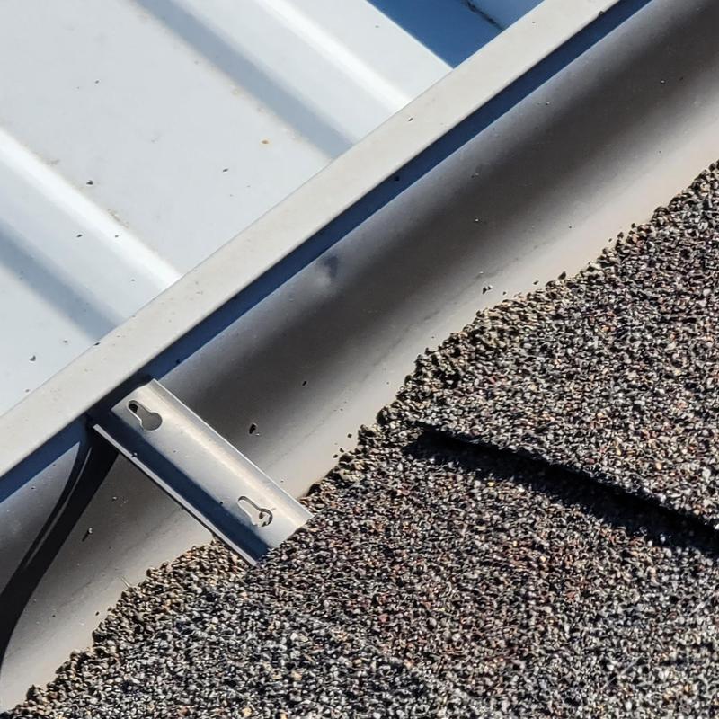Metal roof panel and shingle hail damage close-up