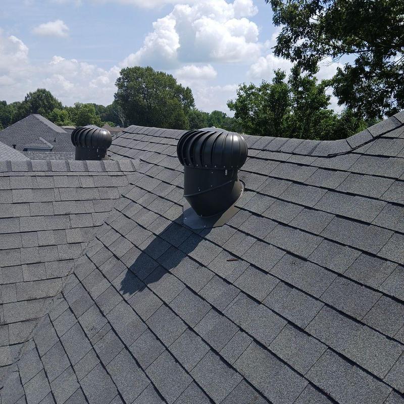 Turbine roof vents on shingle roof under blue sky