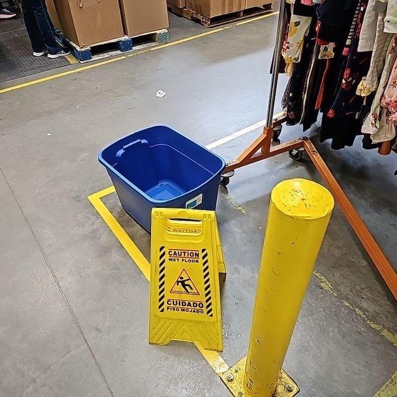 Concrete floor with wet floor caution sign and bucket