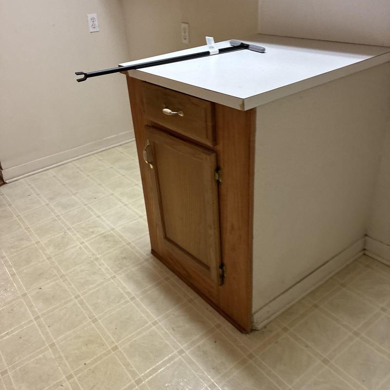 Cabinet with PEX pipe reroute tool on top