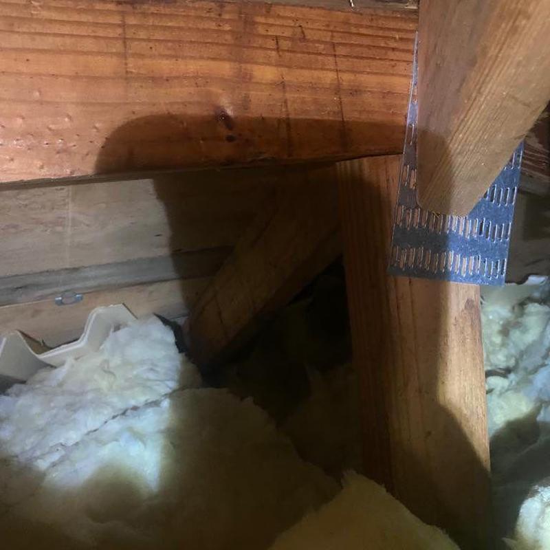 Attic wooden framing and insulation with metal strap