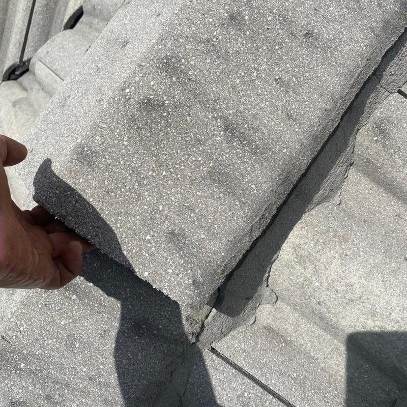Concrete roof tile inspection showing damage and cracks