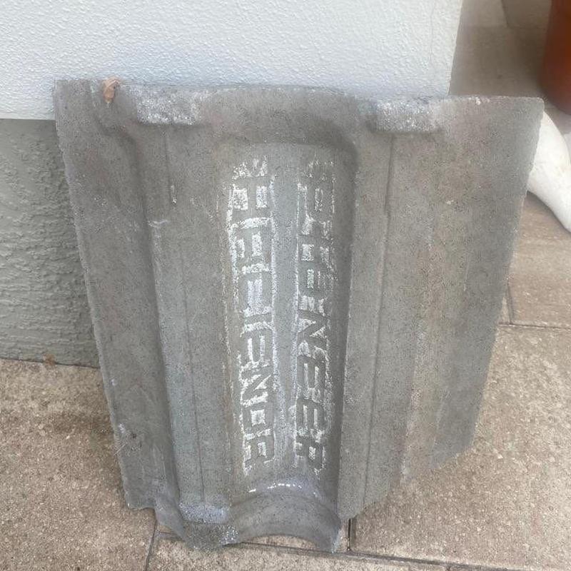 Concrete roof tile with embossed manufacturer markings
