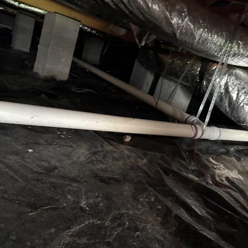 PVC drainage pipes in crawl space with supports