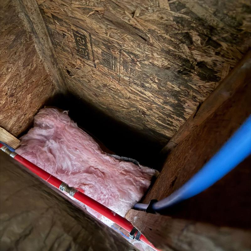 Water supply pipes with attic insulation and plywood sheathing