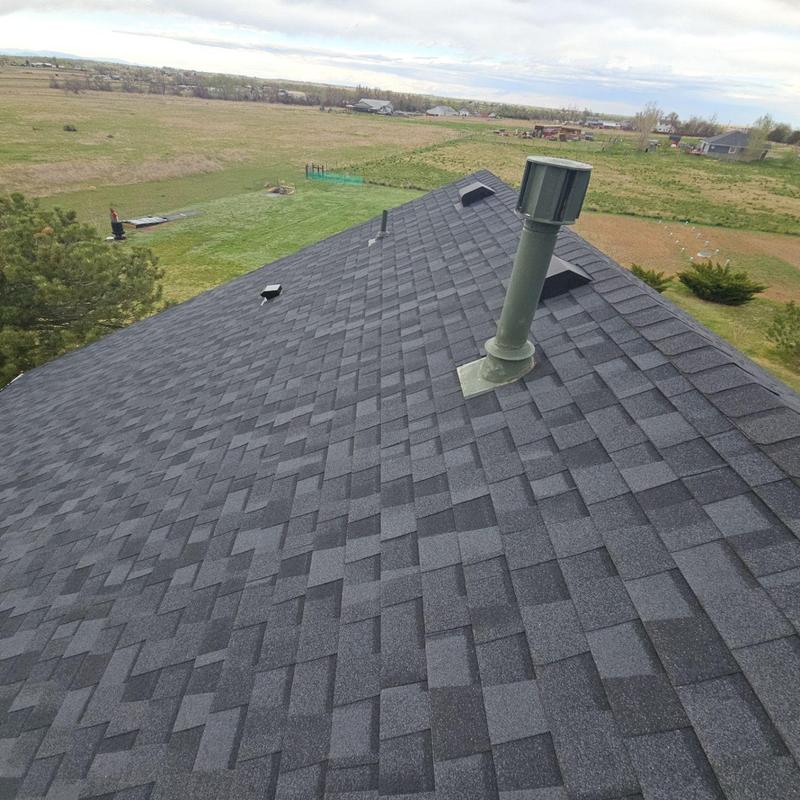 Asphalt shingle roof with vent pipes in rural area