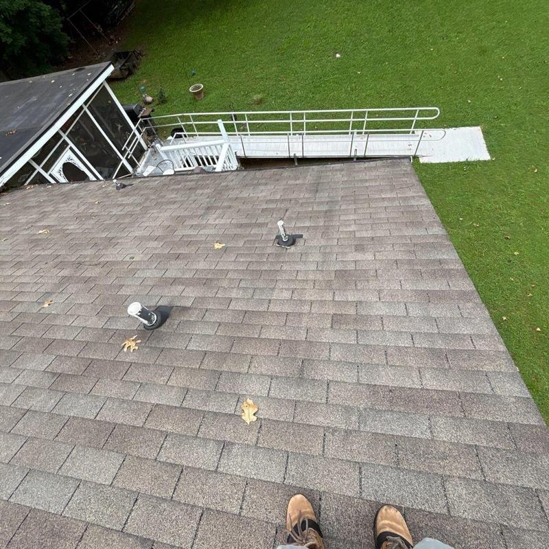 Asphalt shingle roof with visible wear and leaf debris