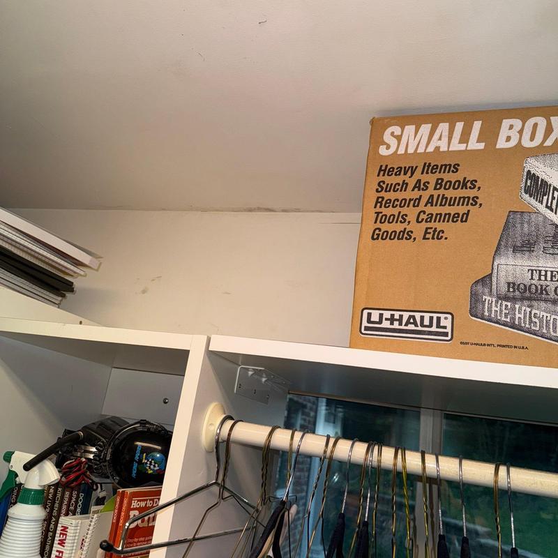 Closet rod with hangers and cardboard storage box