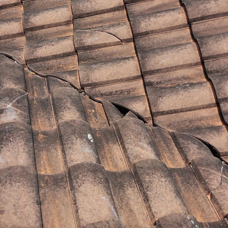 Concrete tile roof with cracked and broken tiles