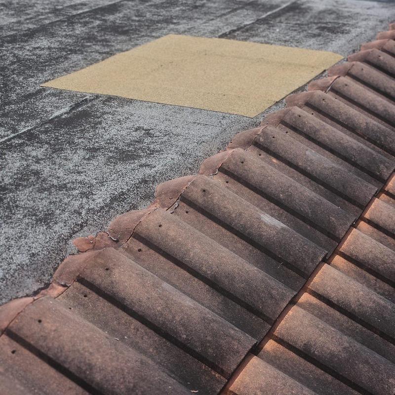 Concrete tile roof with broken tiles and patching