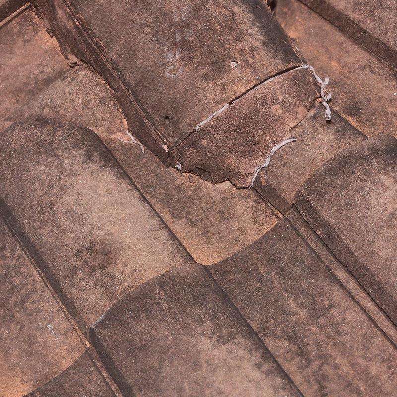 Concrete tile roof with cracked and broken tiles