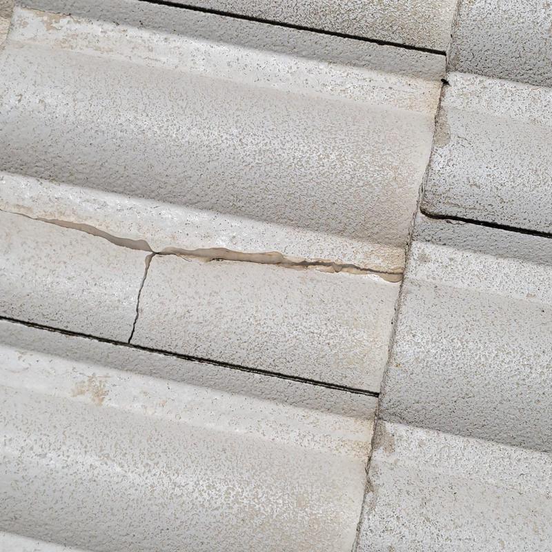 Concrete tile roof with visible cracks and damage