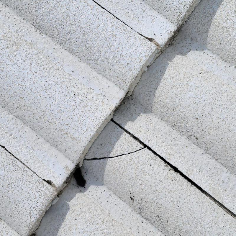 Concrete tile roof with visible crack and gap