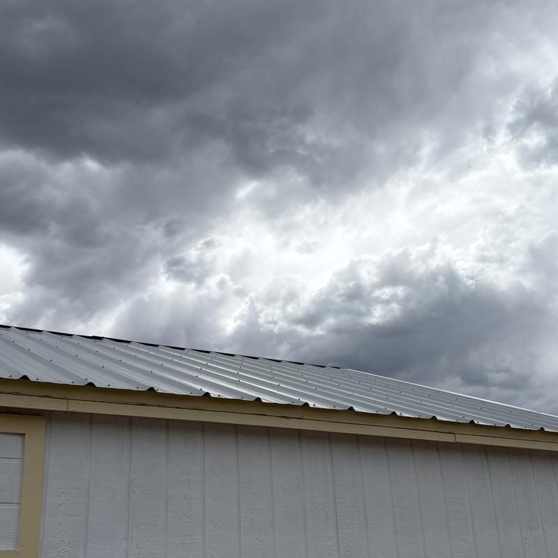 Metal roof panels on building under cloudy sky
