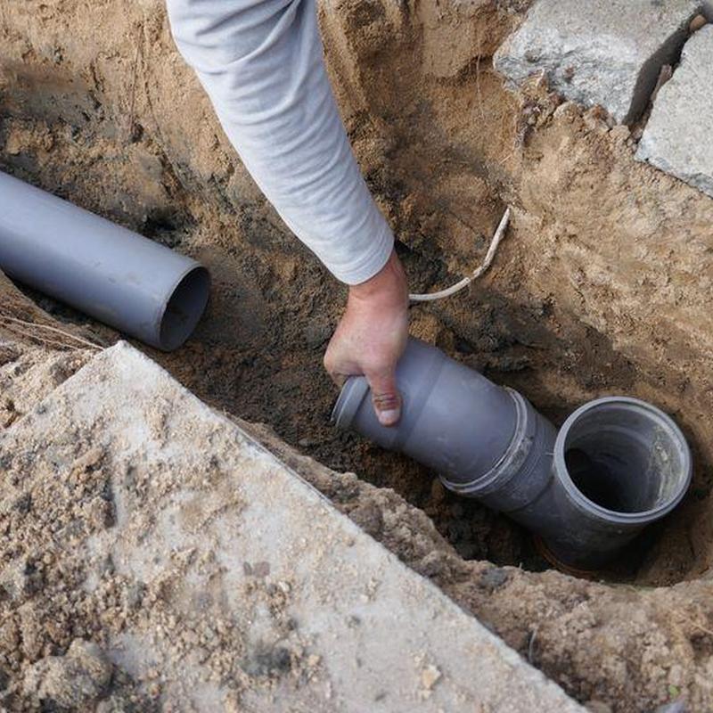 PVC sewer pipe installation in trench dirt