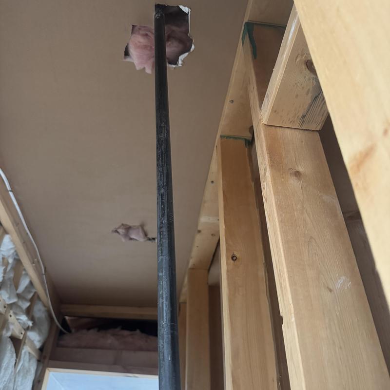 Gas line extending through ceiling insulation and framing