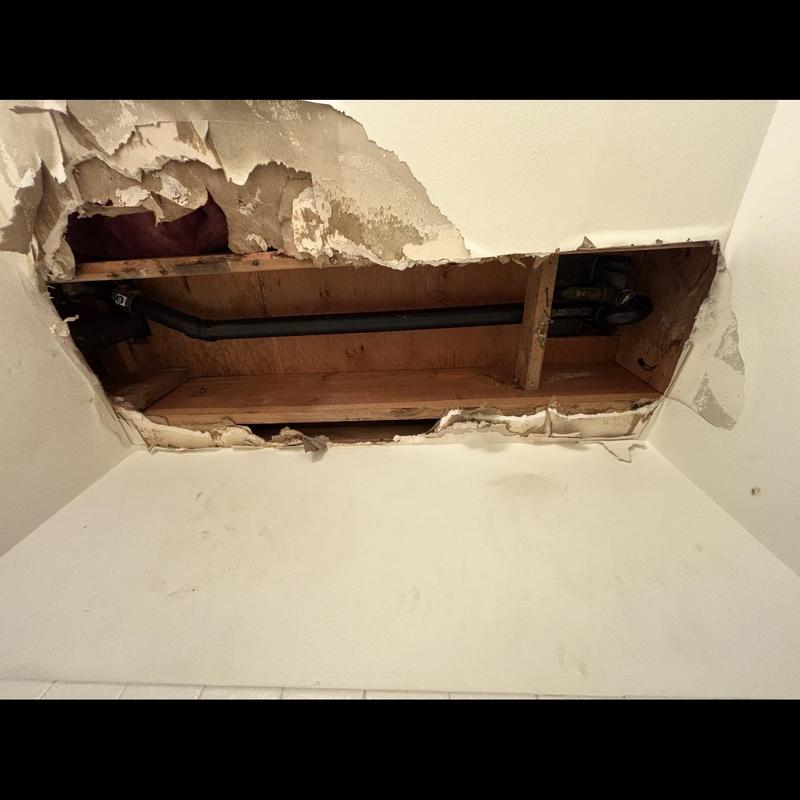 Shower drain pipe with exposed ceiling damage