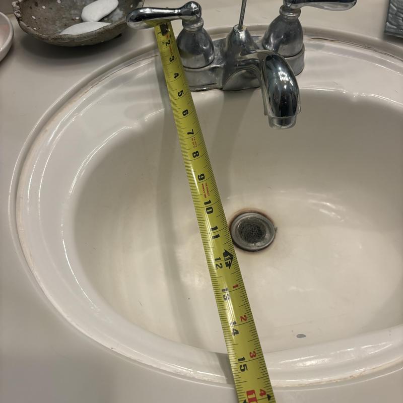 Bathroom sink with faucet and measuring tape