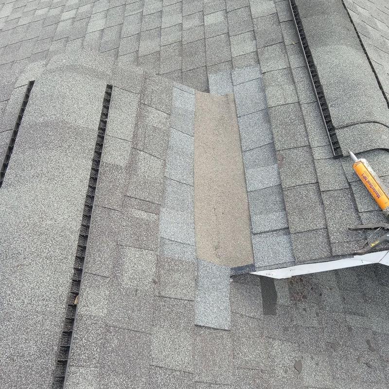 Asphalt shingle patch with roofing sealant on apartment roof