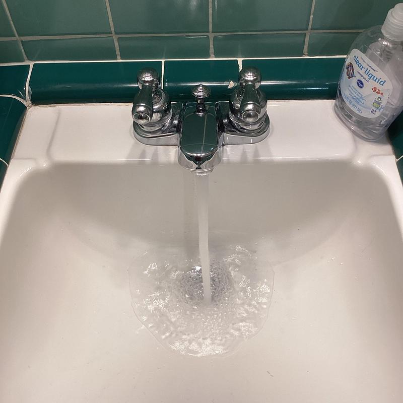 Delta two-handle vanity faucet running water in bathroom sink