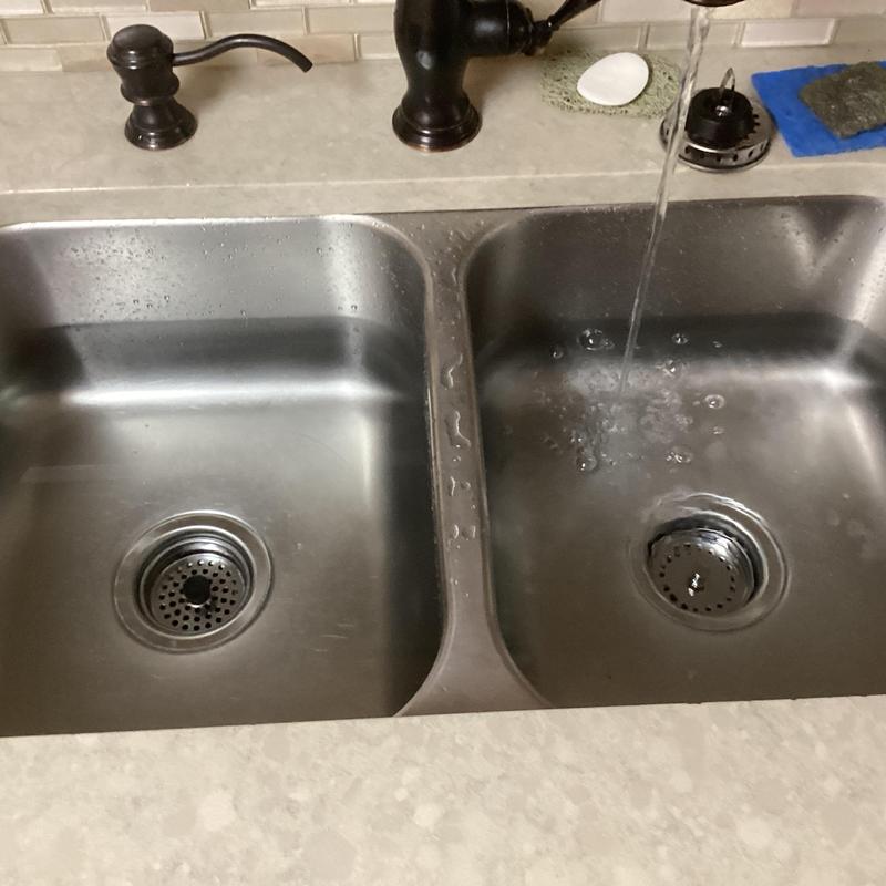 Kitchen sink basket strainers installed and faucet flowing