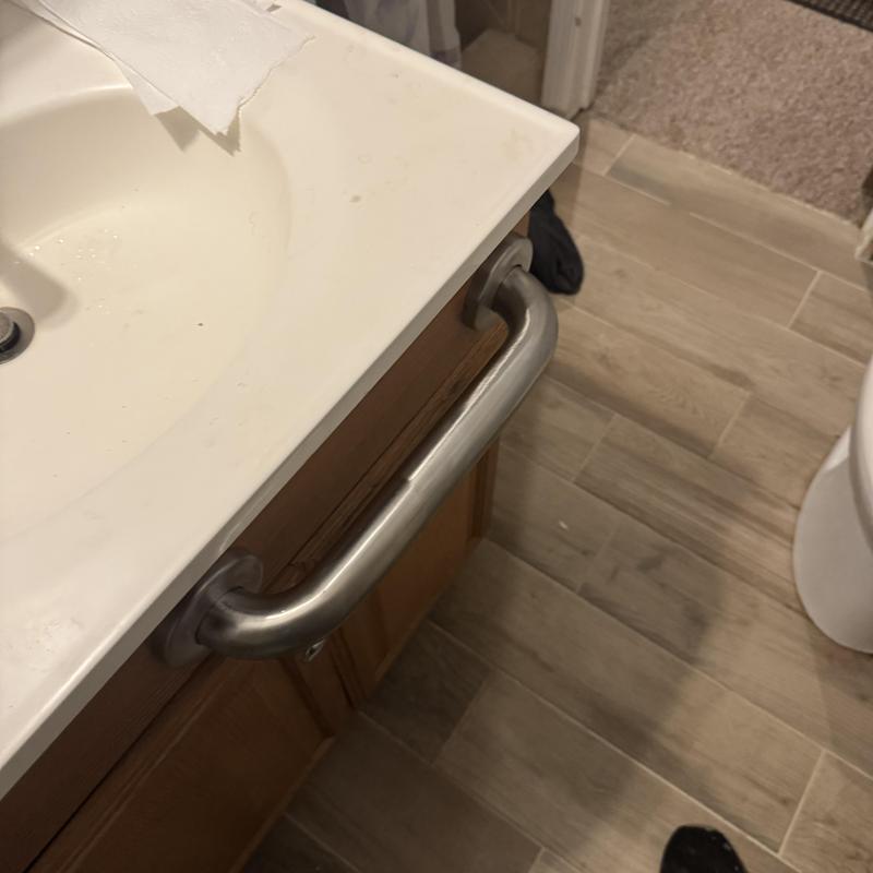 Stainless steel grab bar installed by bathroom sink Stainless steel grab bar installed by bathroom sink