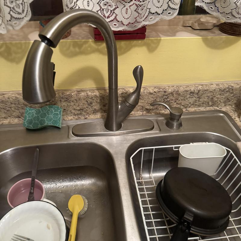 Kitchen faucet and sink with dishes and scrub brush Kitchen faucet and sink with dishes and scrub brush